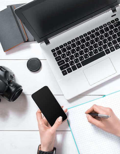 Women taking notes from laptop and the mobile on the table